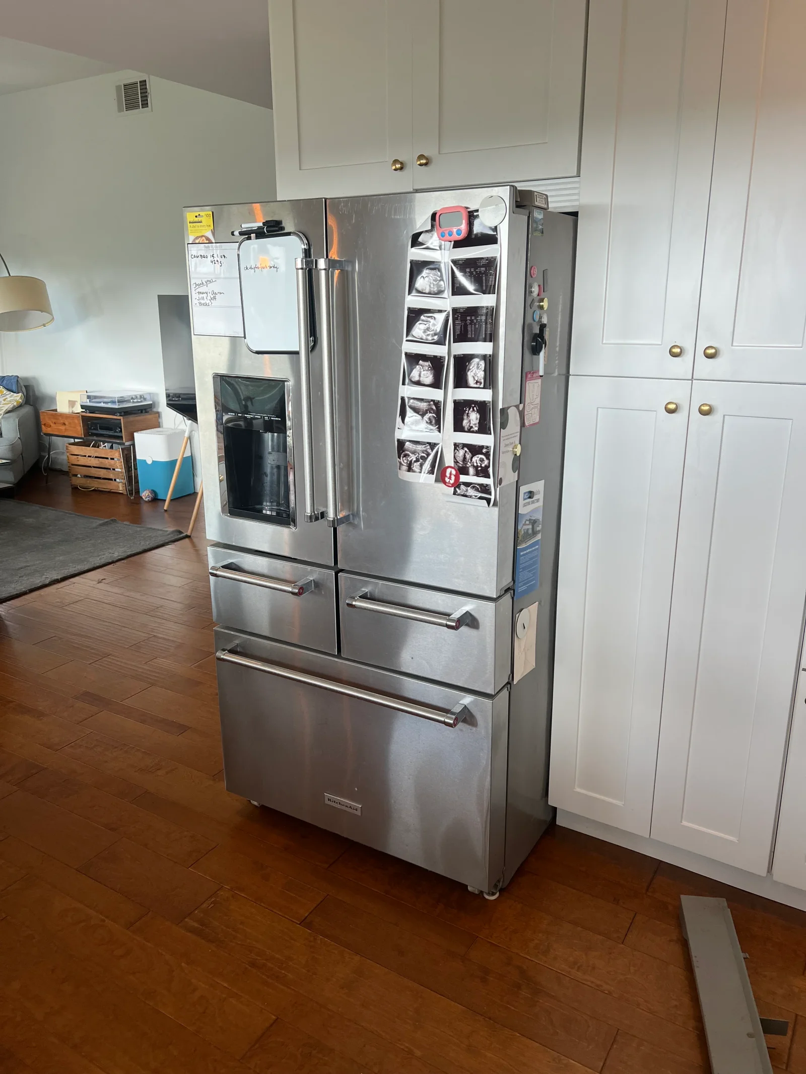 Stainless steel French door refrigerator with multiple drawers and compartments in kitchen setting