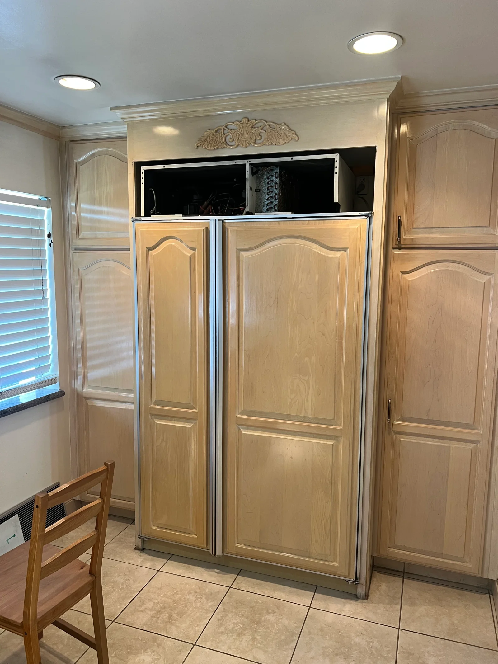 Built-in refrigerator with wood cabinetry, stainless steel trim, and recessed lighting in kitchen