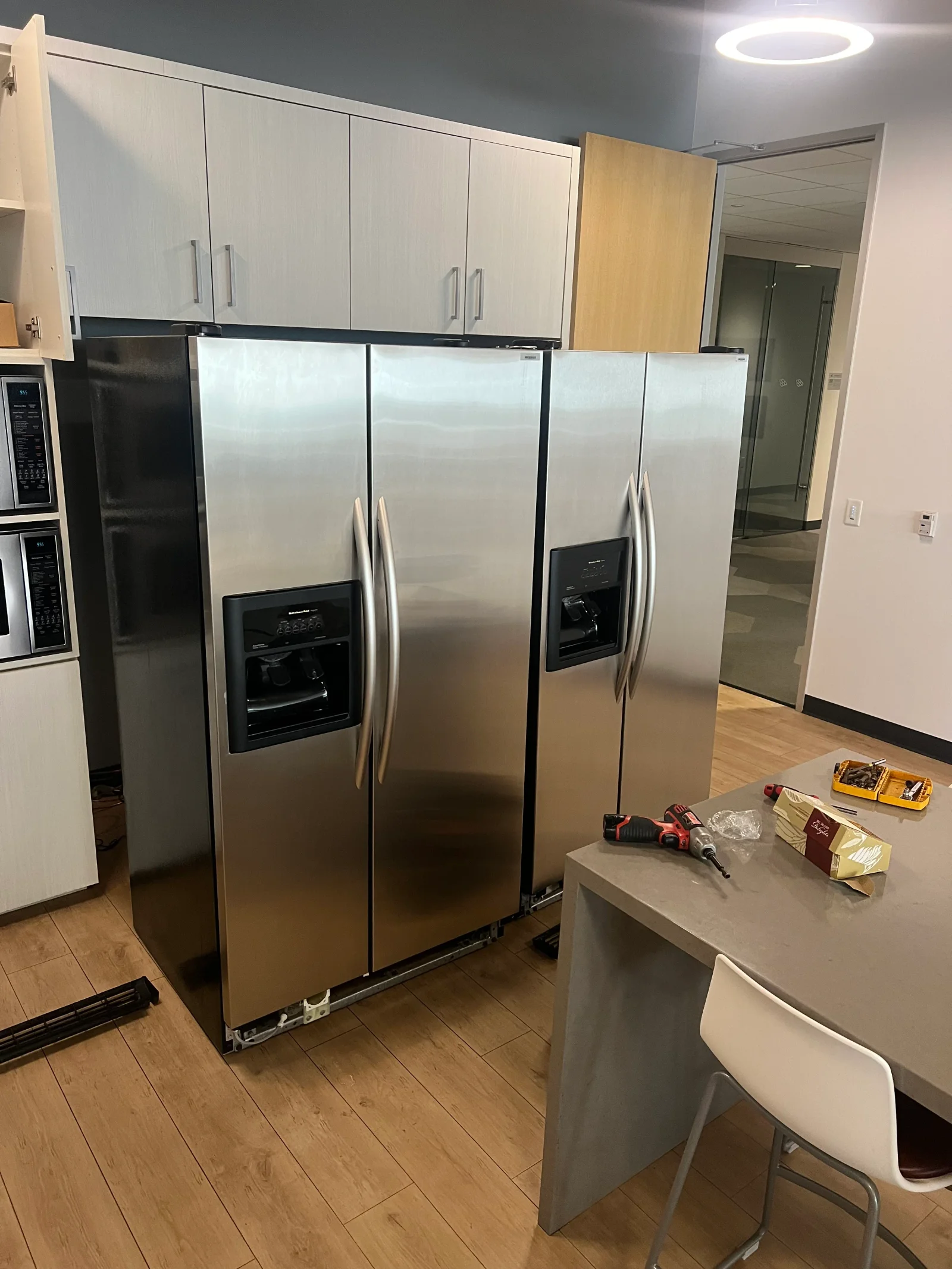 Stainless steel side-by-side refrigerator with ice/water dispensers in kitchen