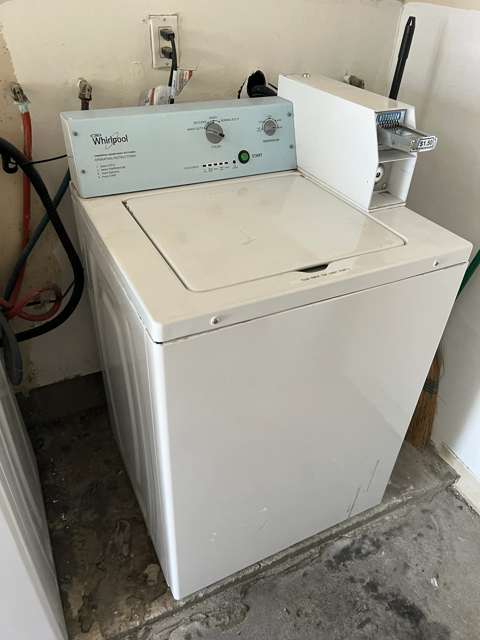 White Whirlpool top-load washer with control panel installed in utility room