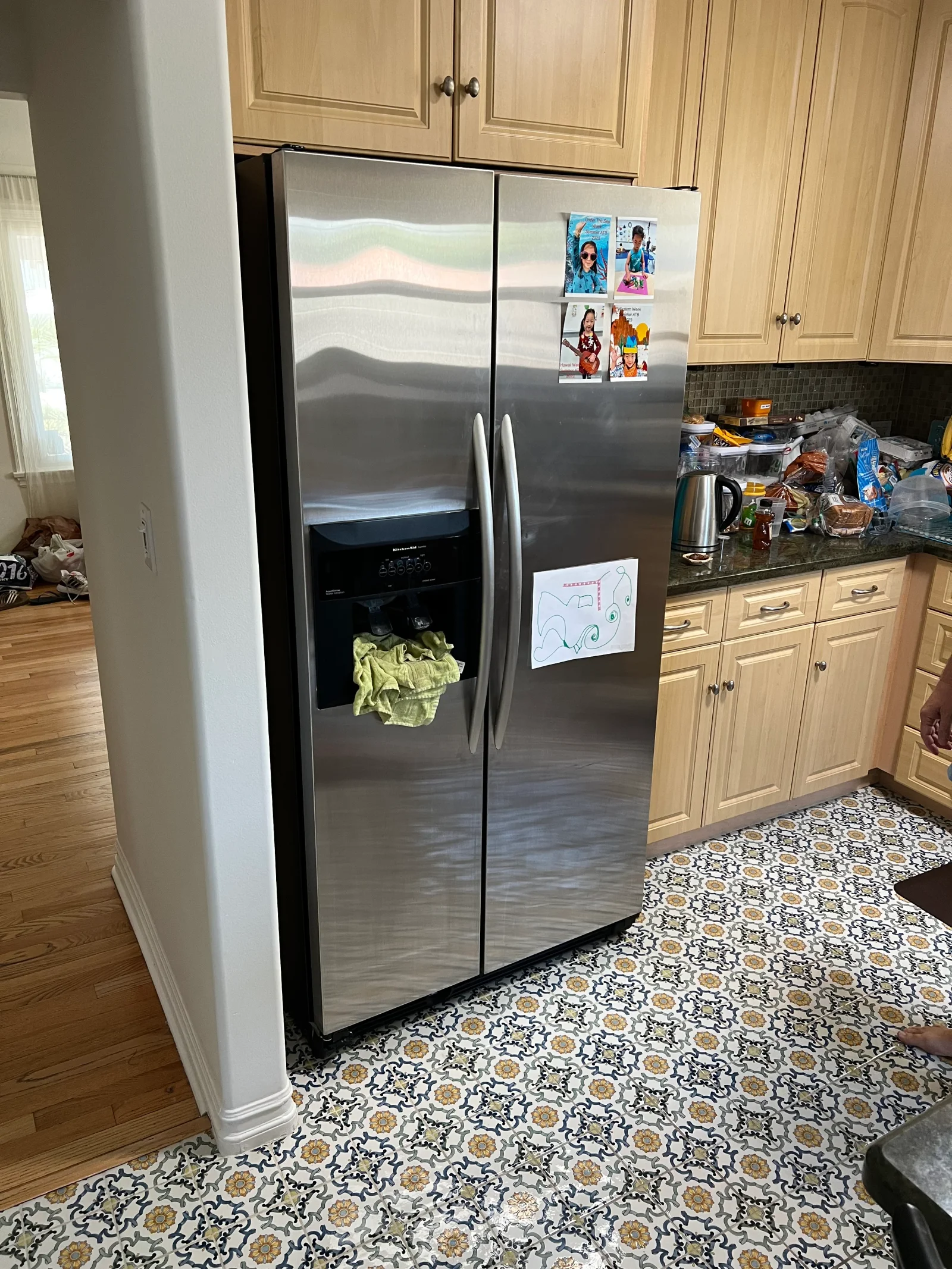 Stainless steel side-by-side refrigerator with ice maker and water dispenser in kitchen