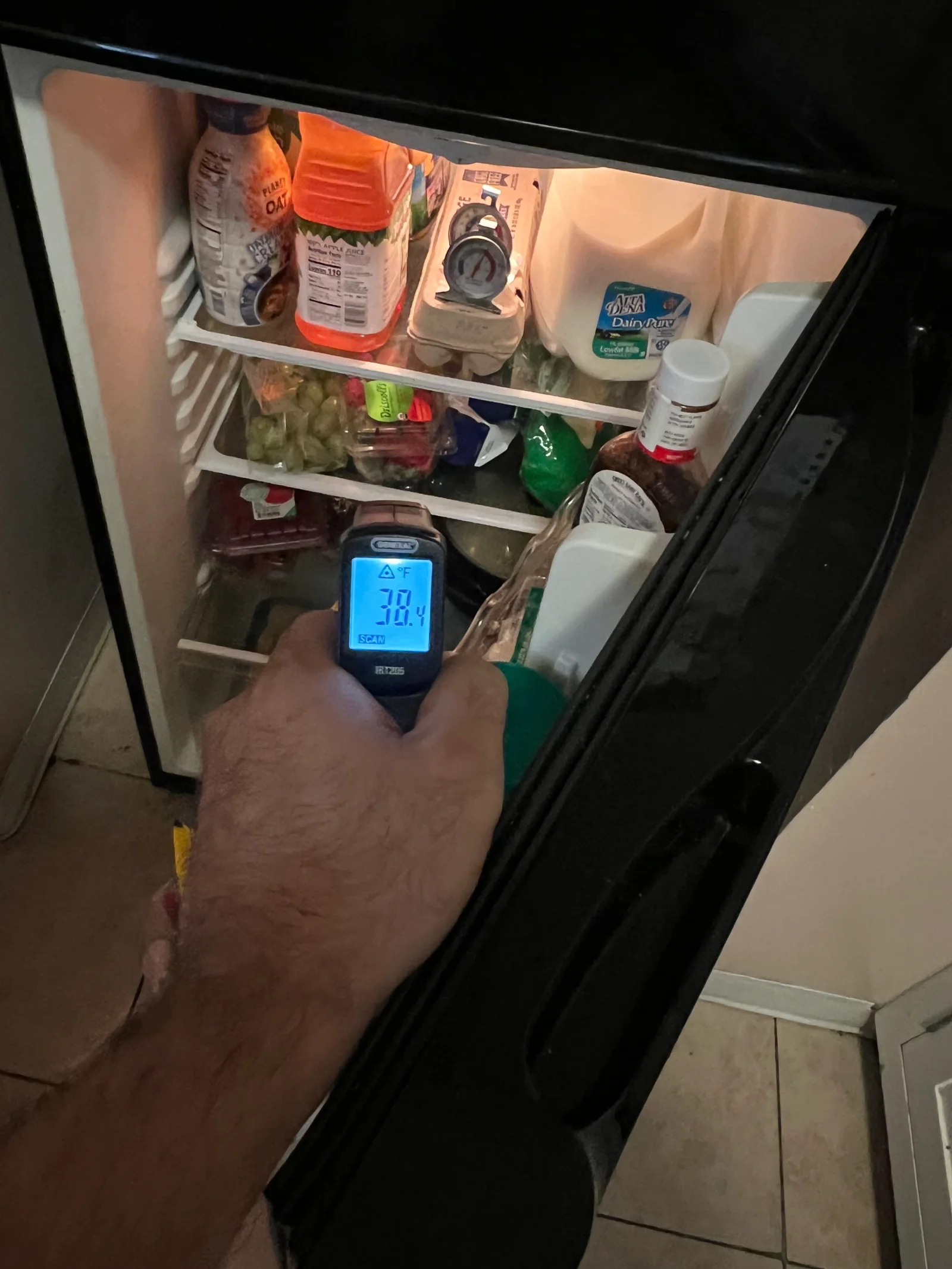 Refrigerator interior with digital thermometer reading temperature during diagnostic service