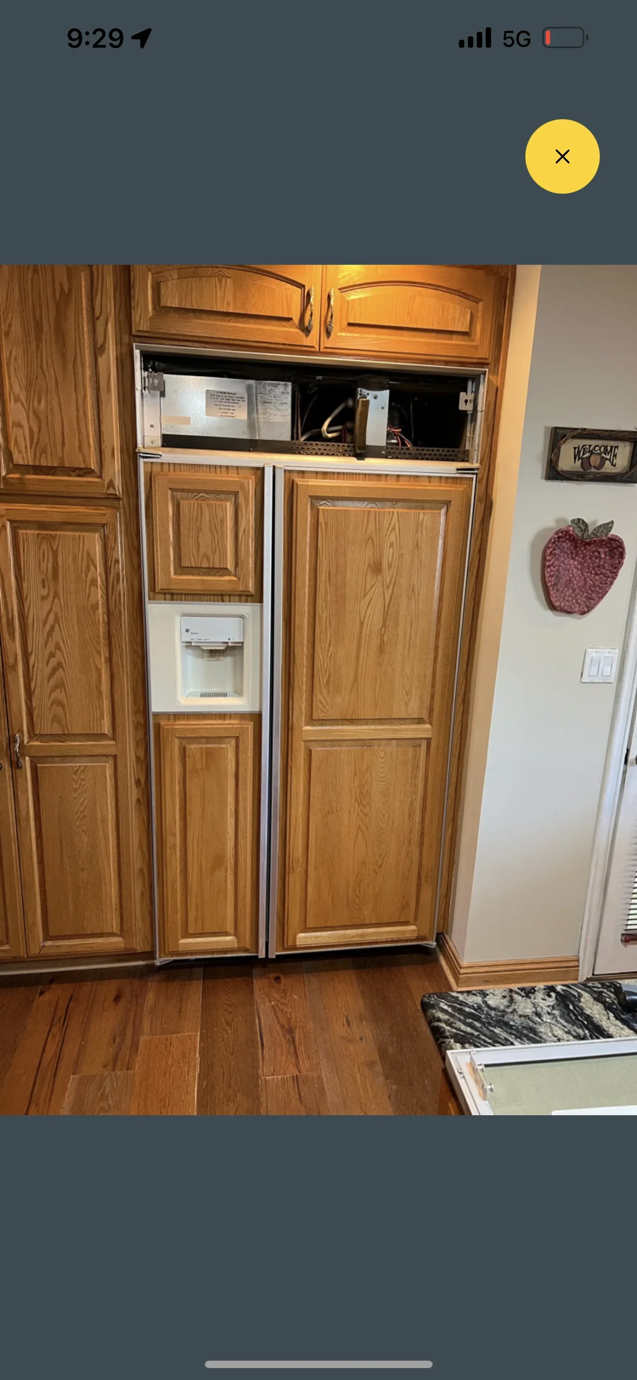 Stainless steel built-in refrigerator installed in oak wood cabinetry with matching panels