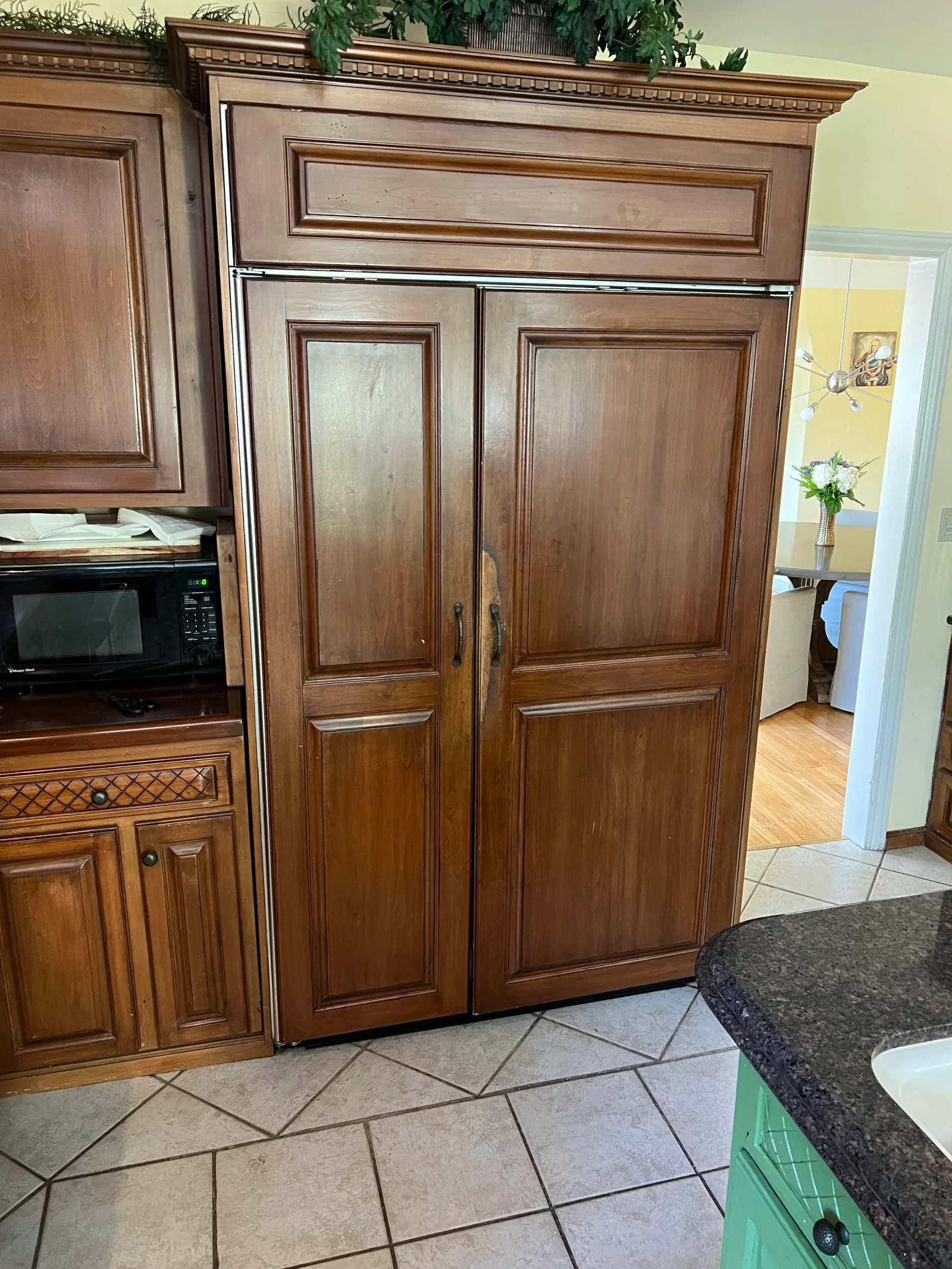 Stainless steel built-in refrigerator installed in wood cabinetry with decorative molding